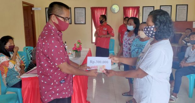 Kepala Desa Komus I, Pirsen Tahulending saat menyerahkan BLT kepada KPM