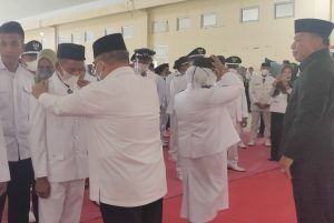 Bupati dan Wakil Bupati Bolmut saat memasang tanda garuda di baju Sangadi Komus II