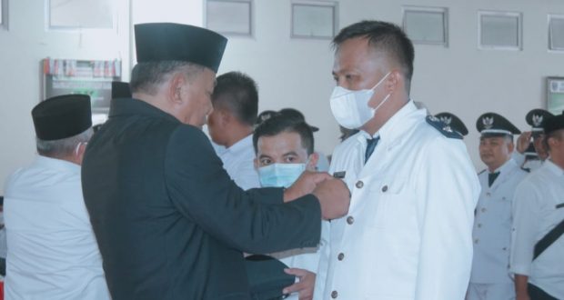 Bupati Bolmut saat memasangkan lambang garuda kepada Sangadi Robby Pakaya